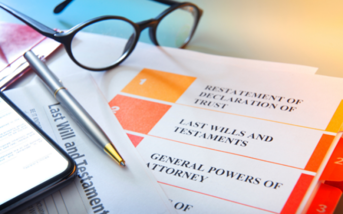 pair of glasses and a pen sitting on top of estate planning documents