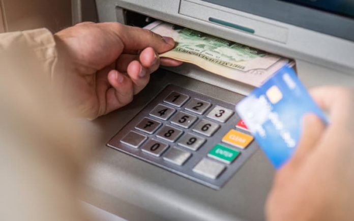 Customer taking cash from ATM