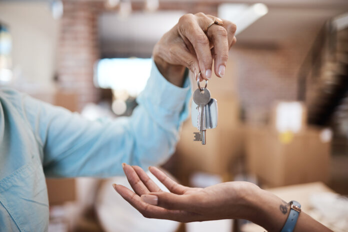 Shot of an unrecognisable handing over the keys to a new house keys in hand