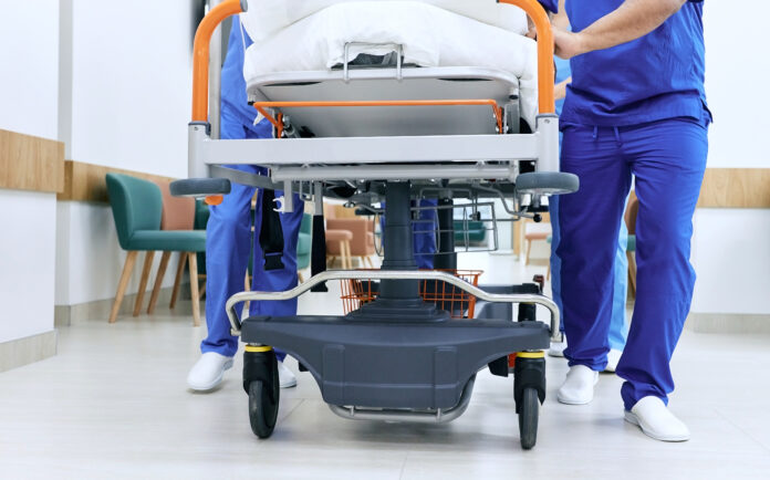medical staff rolling bed down the hallway