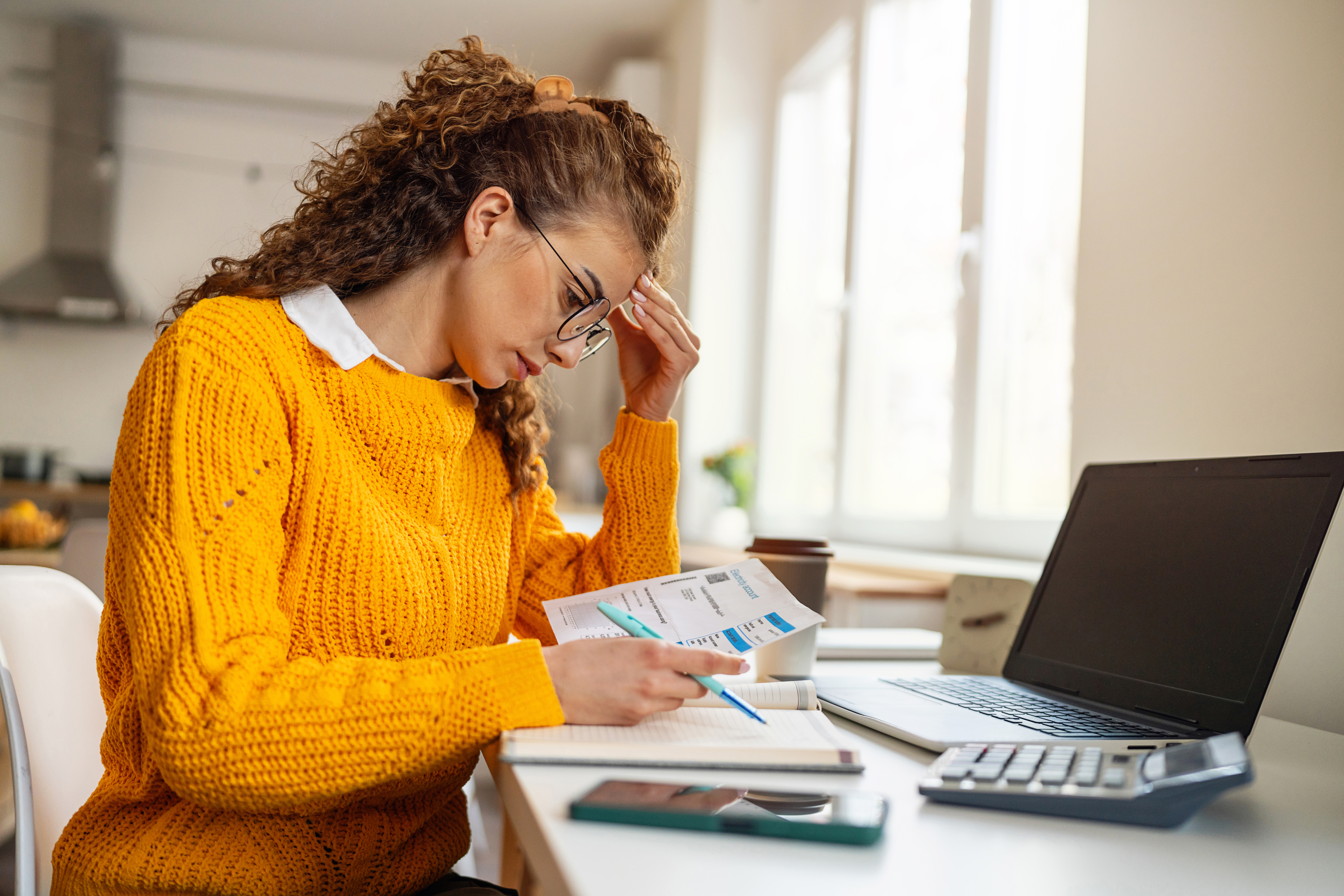 A worried young woman, organizing home finances, during inflation time