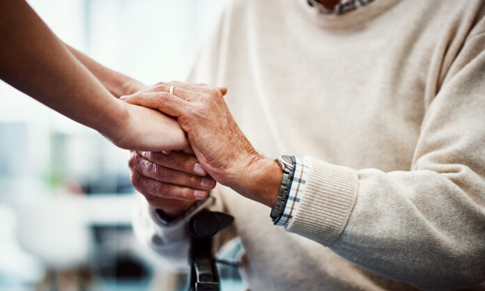 Cropped shot of an unrecognizable female holding her senior parent's hand in comfort