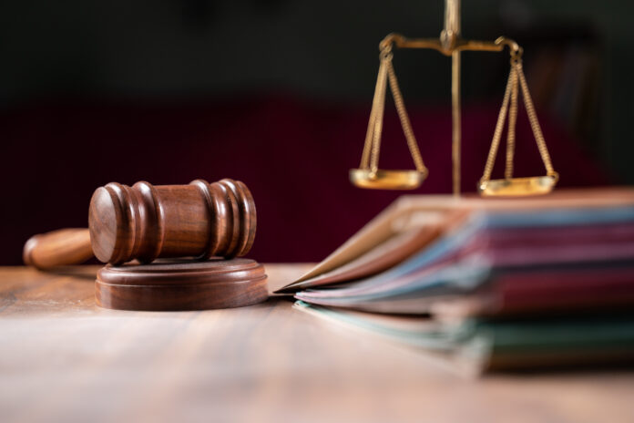 focus on gavel, group of files on judge table covered with dust