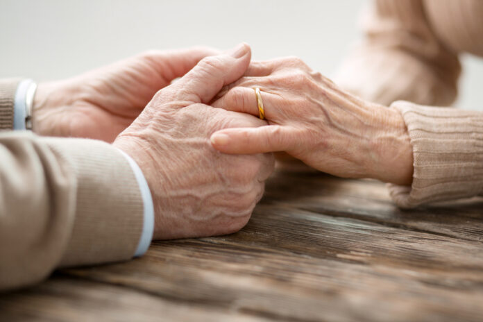 Aged married couple holding hands