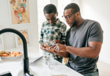 Dad Teaching Basic Money Concepts to his son in the kitchen
