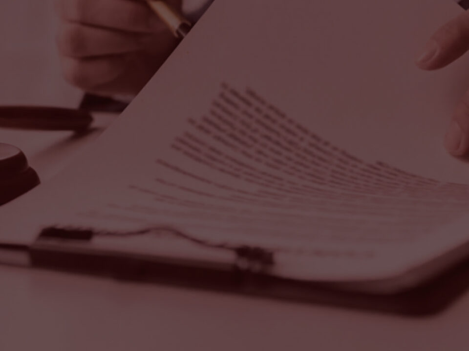Man signing document with judge's hammer next to him